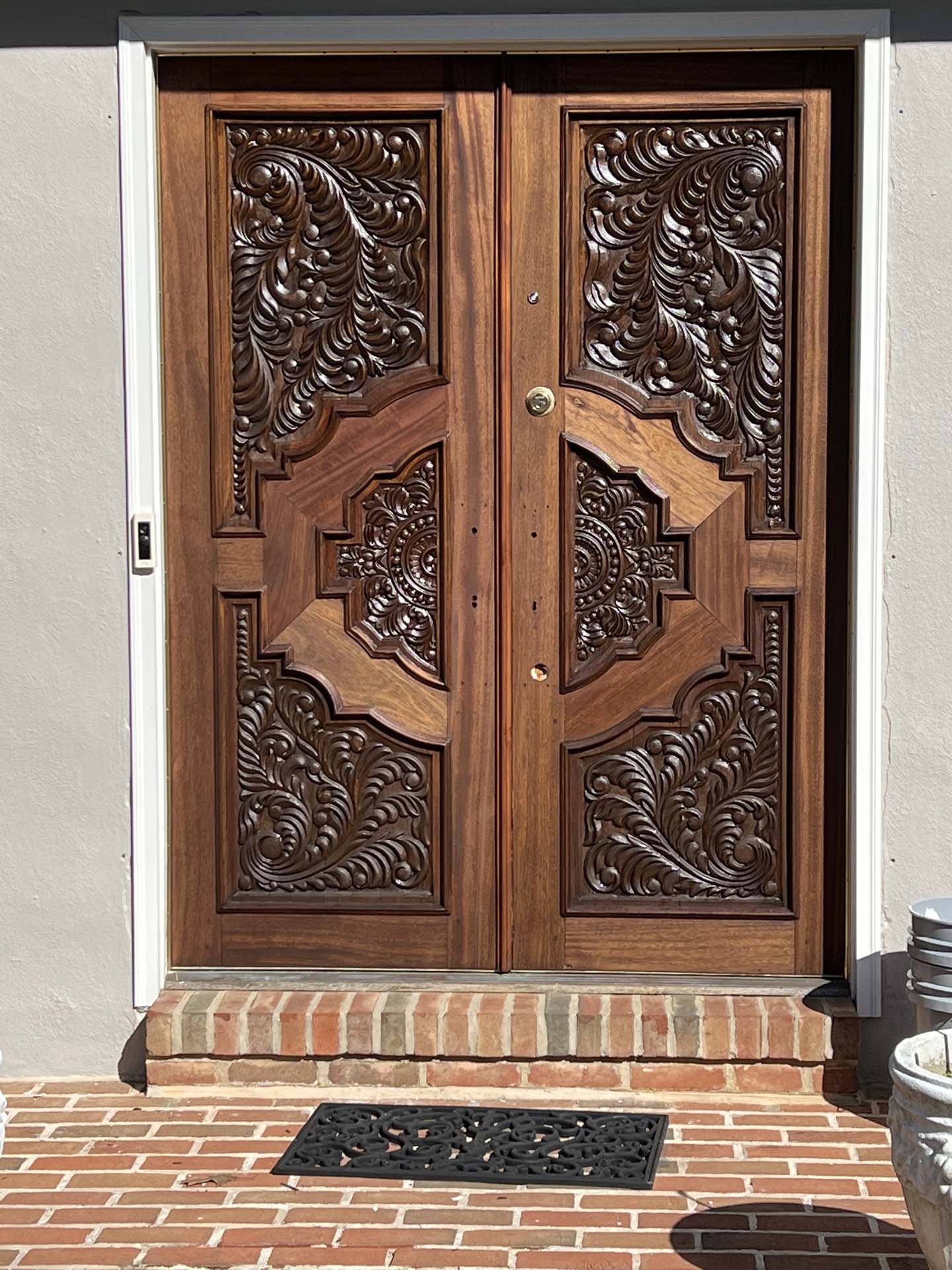 wooden front door with unique design, brick walkway